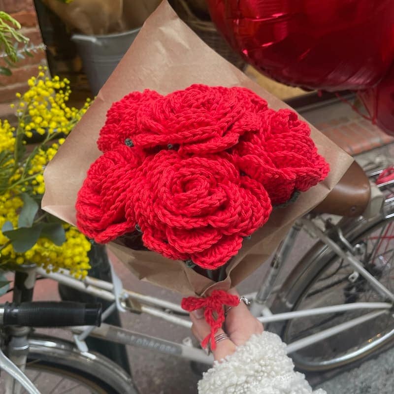 Bouquet de roses rouges au crochet. Faut main avec un emballage en papier kraft.